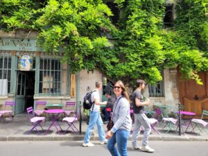 flora walking in Paris as a tour guide of Paris with sunglasses in ile de la cité